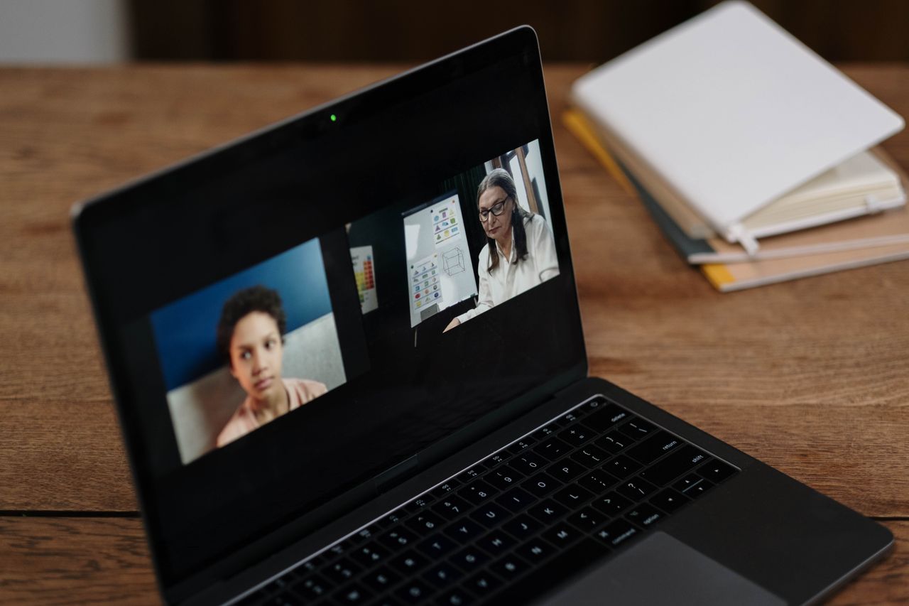 Deux personnes suivant une formation en ligne sur un ordinateur portable, idéal pour illustrer l’apprentissage à distance.